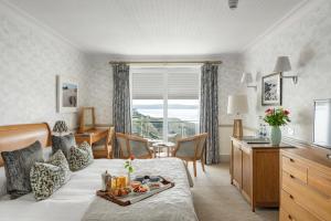 a hotel room with a bed with a tray of food on it at Watersmeet Hotel in Woolacombe