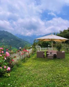 a garden with an umbrella and chairs and flowers at Trabzon saklı villa in Akcaabat