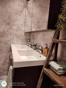 uma casa de banho com um lavatório branco e um espelho. em Isidaura em Zutendaal