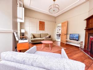 a living room with a couch and a tv at Cardiff Victorian House Sleeps 6 in Roath 15mn City centre in Cardiff