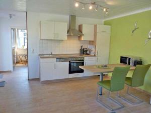 a kitchen with a table and some green walls at Ferienhaus "Brigitte" Objekt ID 12053-4 in Waren