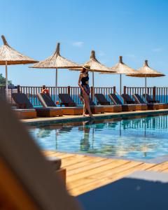 a woman is standing next to a swimming pool at Sea Valley Lodge in Faralya
