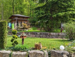 un jardin avec un nourrisseur d'oiseaux et une maison dans l'établissement Pension Am Waldrand, à Mosbach