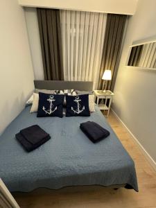 een slaapkamer met een bed met blauwe lakens en kussens bij Rewal Cliff Morska 1 in Rewal +24 foto's