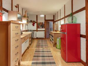 a red refrigerator in a kitchen with wooden floors at Holiday Home Gut Hörne-1 by Interhome in Hörne