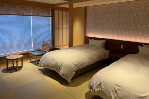 Postel nebo postele na pokoji v ubytování Akaishiya 城崎温泉旅館 赤石屋