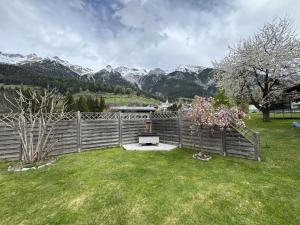 een hek met een bankje in een tuin met bergen bij Apartment Jordan by Interhome in Pettneu am Arlberg +14 foto's