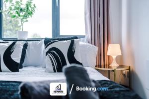 a bed with black and white pillows and a window at 25 percent OFF Monthly Stay By NYOS PROPERTIES Short Lets & Serviced Accommodation Manchester Business Leisure in Manchester