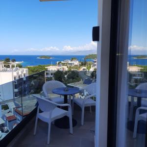 balcone con tavolo, sedie e vista sull'oceano di HOTEL RENATO a Ksamil