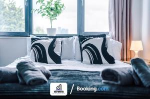 a bed with black and white pillows and a window at 25 percent OFF Monthly Stay By NYOS PROPERTIES Short Lets & Serviced Accommodation Manchester Business Leisure in Manchester