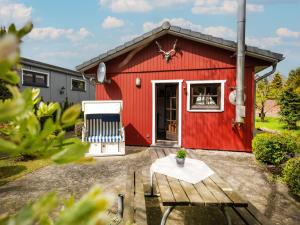 a red barn with a table in front of it at Chalet Am Fleet by Interhome in Osten