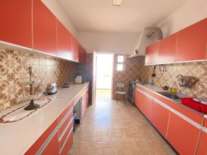 una cucina con armadi rossi e ripiani bianchi di Bia Vintage Villa - Casa com Vista Mar, Terraço e Jardim no Centro de Alvor ad Alvor