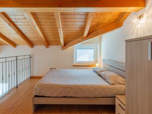 - une chambre avec un lit dans une pièce dotée de plafonds en bois dans l'établissement Apartment Marco by Interhome, à Riva