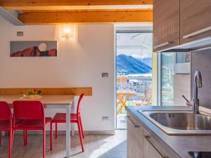une cuisine avec des chaises rouges et une table avec un évier dans l'établissement Apartment Marco by Interhome, à Riva