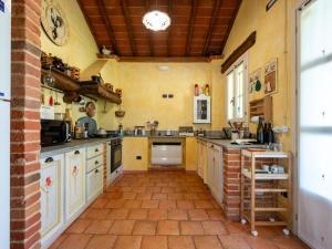 uma grande cozinha com paredes amarelas e piso em tijolo em Holiday Home Il Valletto by Interhome em Mombaruzzo