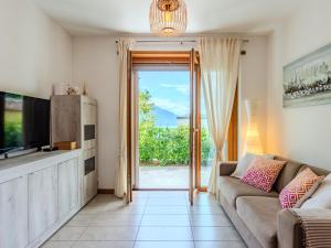 ein Wohnzimmer mit einem Sofa und einer Glasschiebetür in der Unterkunft Apartment San Vincenzo by Interhome in Gera Lario