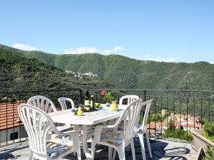 una mesa blanca y sillas en un balcón con montañas en Apartment Il Loggiato - TVE170 by Interhome, en Tavole