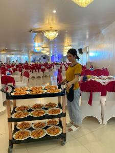 a woman is standing next to a buffet of food at Nhà hàng - Khách sạn Sơn Nữ in Bak Kan