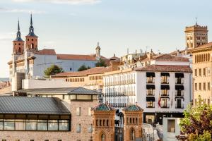 a city skyline with buildings and a church at Hotel Reina Cristina in Teruel