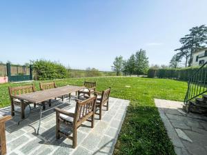 een houten picknicktafel en banken in een park bij Holiday Home Villa Remotti by Interhome in Fubine