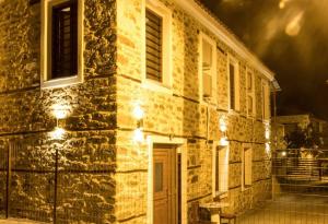 a building with lights on the side of it at night at MARIANTHI'S STONE HOUSE- Studio2 in Metangítsion