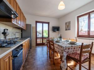 una cocina con mesa con sillas y mantel. en Holiday Home Monte San Giulio by Interhome, en Pella