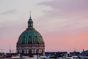 a dome of a building with a cross on top at Wonderful 2-bed wbalcony in top Frederiksberg location in Copenhagen