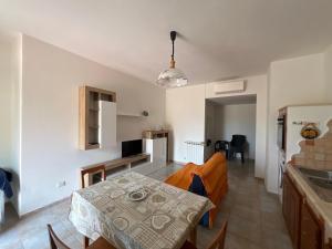 a kitchen and a living room with a table and a couch at Villa Maccioni in Budoni