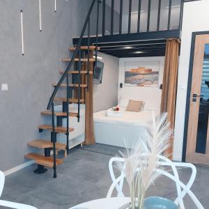 een slaapkamer met een bed en een wenteltrap bij Apartament typu studio Morski Sen-centrum in Mielno