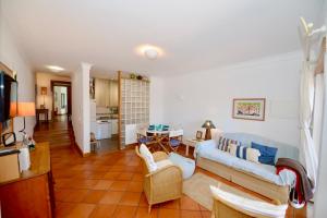 a living room with a couch and a table at Paddle - Sea view apartment with 3 pools, tennis & squash court in São Martinho do Porto