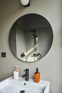 a bathroom with a mirror above a sink at stilwerk Strandhotel Blankenese in Hamburg