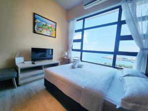 a bedroom with a bed and a large window at Jesselton Quay Kota Kinabalu City Centre by LW Suites in Kota Kinabalu