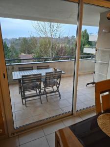 d'une terrasse avec une table et des chaises sur un balcon. dans l'établissement Résidence CAP HORIZON, à Brive-la-Gaillarde