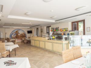 a restaurant with a counter and tables and chairs at Domus Laetitiae Assisi in Assisi