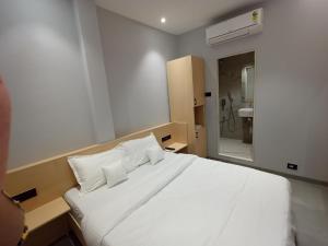 a bedroom with a bed with white sheets and pillows at Hotel Golden Suites - Near Nesco in Mumbai