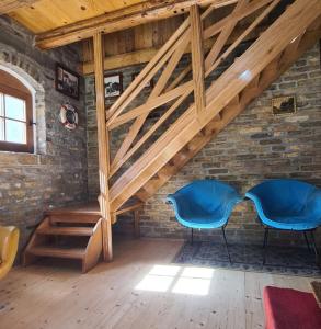 due sedie blu in una stanza con un muro di mattoni di Vikendica Kapetan Bajski a Bezdan