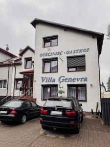 two cars parked in front of a building at Villa Genevra in Koszalin