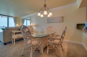 a dining room and living room with a table and chairs at Spectacular Sunsets at this Beachfront Condo in Bradenton Beach