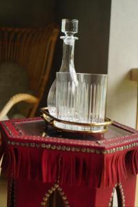 una botella de vidrio sobre una mesa con un mantel rojo en Ola Foundation Residence en Riga