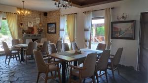 una sala da pranzo con tavoli e sedie in legno di Hotel Margjeka a Valbona