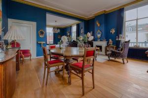 a dining room with blue walls and a table and chairs at Villa Dalenstein in Velp