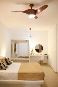 - une chambre avec un lit et un ventilateur de plafond dans l'établissement AK Suites, à Imerovigli