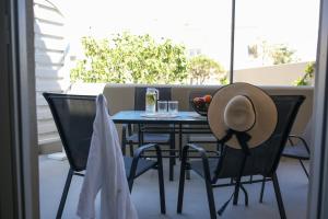 a table and chairs with a hat on a balcony at AK Suites in Imerovigli
