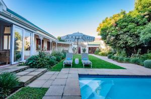 two blue and white chairs sitting next to a swimming pool at Bonne Esperance Villa in Stellenbosch