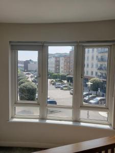a window with a view of a parking lot at Indomitable in Colindale