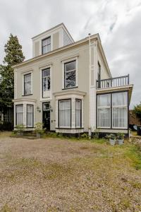 Cette grande maison blanche possède de nombreuses fenêtres. dans l'établissement Villa Dalenstein, à Velp