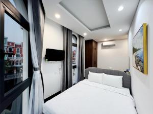 a small bedroom with a bed and a window at Legacy Hotel - Grand World Phú Quốc in Phú Quốc