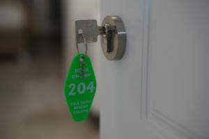 une étiquette verte suspendue à une poignée de porte dans l'établissement Vila Sofia Gllava - Resort, à Memaliaj