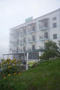 un edificio con balconi e fiori di fronte di Vila Sofia Gllava - Resort a Memaliaj