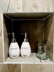 two soap dispensers are sitting on a shelf at Legacy Phú Quốc in Phu Quoc